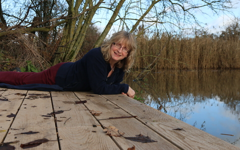 Nicky sits on the edge of a lake